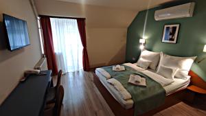 a hotel room with a bed with two towels on it at Átrium Hotel Harkány in Harkány