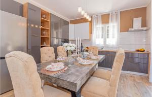 a kitchen with a dining room table and chairs at 3 Bedroom Gorgeous Home In Jadrtovac in Jadrtovac