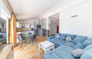 a living room with a blue couch and a table at Gorgeous Home In Vinisce With Jacuzzi in Vinišće