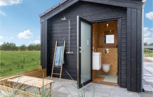a black shed with a toilet and a chair at Stunning Home In Jerup With Wifi in Jerup +17 photos