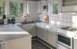 a kitchen with white cabinets and a stove top oven at 1 Bedroom Amazing Home In Överlida in Överlida