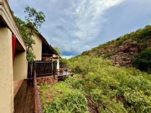 a building with a balcony next to a mountain at The Riverine Lodge in Welgevonden Game Reserve