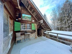 a porch of a log cabin with a table and chairs at Rougemont Hideaway chalet by the river in Rougemont