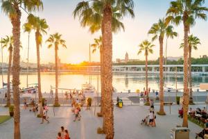 a group of people walking around a marina with palm trees at Malaga Cozy House- Nature in Málaga