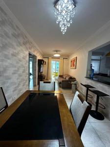 a living room with a table and a couch at Apartamento completo no Centro- Mongaguá Pé na areia in Mongaguá