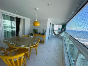 a dining room with a table and chairs on a balcony at Apartamento completo no Centro- Mongaguá Pé na areia in Mongaguá
