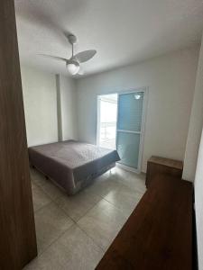a bedroom with a bed and a window at Apartamento completo no Centro- Mongaguá Pé na areia in Mongaguá +16 photos
