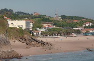 a group of people on a beach near the ocean at Hotel Josein in Comillas