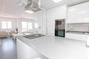ムルシアにあるApartamento Céntrico Salzilloの白いキッチン(カウンタートップ付)、リビングルーム