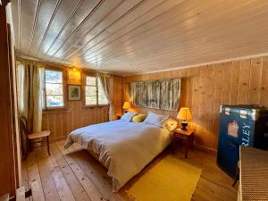 a bedroom with a bed in a room with wooden walls at 300 years old Chalet close to Center ski-lift in Chateau-d'Oex