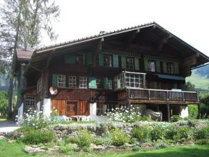 a large wooden house with a porch and balcony at 300 years old Chalet close to Center ski-lift in Chateau-d'Oex