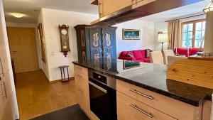 格施塔德Gstaad - Luxury Flat in Saanen的一个带台面的厨房和一间客厅