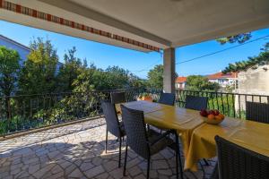eine Terrasse mit Tisch und Stühlen auf einem Balkon in der Unterkunft Apartments Pinty in Jadranovo
