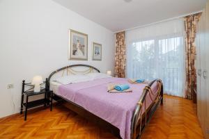 ein Schlafzimmer mit einem Bett und einem großen Fenster in der Unterkunft Apartments Pinty in Jadranovo