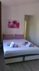 ein Schlafzimmer mit einem großen Bett mit lila Kissen in der Unterkunft Apartments and Room Rest in Sumartin