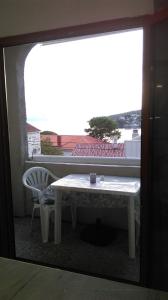 ein Tisch und ein Stuhl in einem Zimmer mit Fenster in der Unterkunft Apartments and Room Rest in Sumartin + 70 Fotos