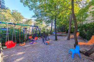einen Spielplatz mit bunten Schaukeln in einem Park in der Unterkunft Apartments Pinty in Jadranovo