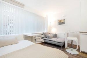 a white room with a bed and a couch at Apartments Craven Terrace in London