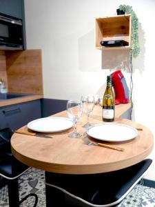 a table with two glasses and a bottle of wine at La Belle vigne - Chablis Centre in Chablis