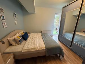 a bedroom with a bed and a large mirror at 4 Seasons Apartment Sinaia in Sinaia