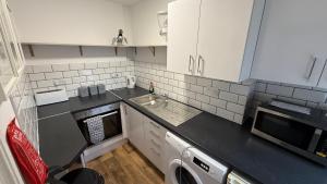 a small kitchen with a sink and a dishwasher at Hotel 119 in Darlington