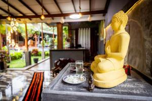 Una statua di una donna seduta su un tavolo di Hotel Samanala Sigiriya a Sigiriya