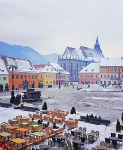 een stad met tafels en stoelen in de sneeuw bij DIN Residence in Braşov