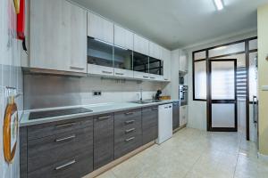 a kitchen with brown cabinets and a white refrigerator at Cozy and Quiet Spacious Flat in Vila Nova de Gaia +13 photos