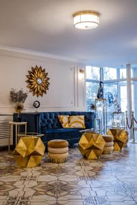 a living room with a blue couch and yellow chairs at Prawdzic Family Resort & Wellness in Gdańsk