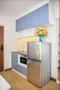 a kitchen with a refrigerator and a vase of flowers at Raspberry Mansion ราสเบอรี่ แมนชั่น in Samutprakarn +7 photos