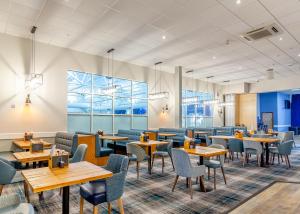 a restaurant with tables and chairs and windows at Apartment with Access to Pool Spa & Soft play in Ilfracombe