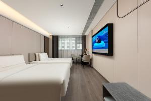 a hotel room with two beds and a flat screen tv at Atour Hotel Guilin Elephant Trunk Hill Sun and Moon Twin Pagodas in Guilin