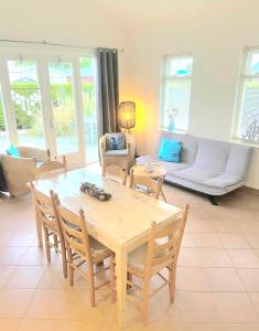 a living room with a wooden table and chairs at Huisje Finn, met grote tuin en veel privacy in Dirkshorn