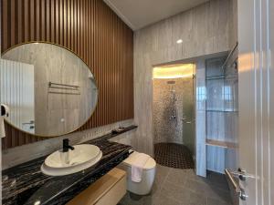 un bagno con lavandino, specchio e doccia di Gracia Spa Resort Hotel a Ciater
