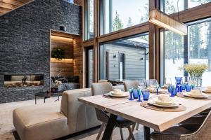 a dining room with a table and chairs and a fireplace at Villa Minna, Brand New Luxury Villa in Ylläs, Lapland in Äkäslompolo