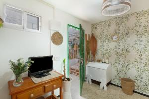 ein Zimmer mit Fernseher und Schreibtisch mit Computer in der Unterkunft Casa vacacional La Finca González in Tenteniguada