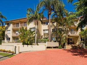an apartment building with a bench in front of it at Bayview Waters Apartments in Gold Coast