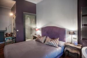 a bedroom with purple walls and a bed with pillows at Terrazza Munira Trastevere in Rome