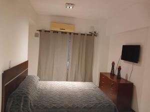 a bedroom with a bed and a dresser and a television at TORRES DEL TUCUMAN I in San Miguel de Tucumán