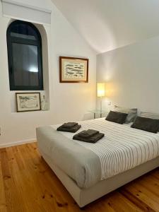 ein Schlafzimmer mit einem großen weißen Bett mit einem Fenster in der Unterkunft Casa da Beira Mar in Aveiro