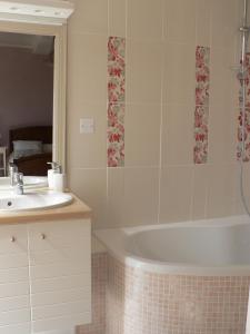 a bathroom with a bath tub and a sink at La Terrasse de la Grand'Rue - chambre d'hôtes - in Mugron