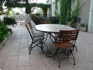 una mesa y sillas en un patio en La Terrasse de la Grand'Rue - chambre d'hôtes - en Mugron