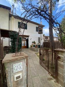 a house with a gate with a clock on it at La Lanterna in Collesalvetti