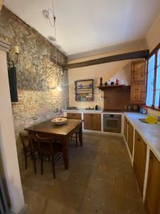 a kitchen with a wooden table and a stone wall at La Lanterna in Collesalvetti