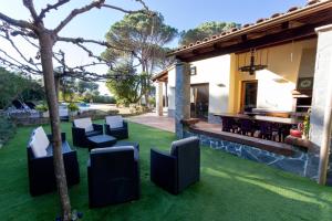 a patio with chairs and a table on grass at Spacious Countryside Costa Brava Relax in Vidreres