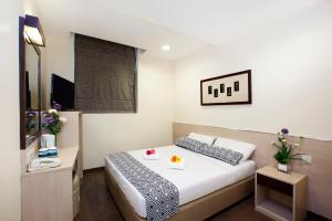 une chambre d'hôtel avec un lit et une télévision dans l'établissement Hotel 81 Fuji, à Singapour
