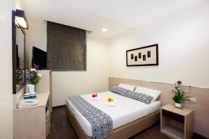 a hotel room with a bed and a television at Hotel 81 Fuji in Singapore