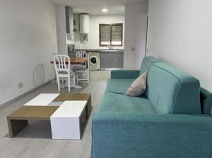 a living room with a blue couch and a table at Turyva Tarongers 4 - Stylish 1-Bed Apartment in Peníscola Near Beach in Peñíscola