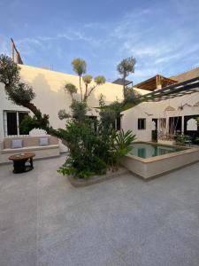 a house with a courtyard with a swimming pool at Elegant Marrakech Villa with Optional Heated Pool for Ultimate Relaxation in Touggana