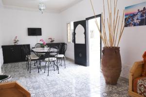 a dining room with a table and chairs and a vase at Elegant Marrakech Villa with Optional Heated Pool for Ultimate Relaxation in Touggana
